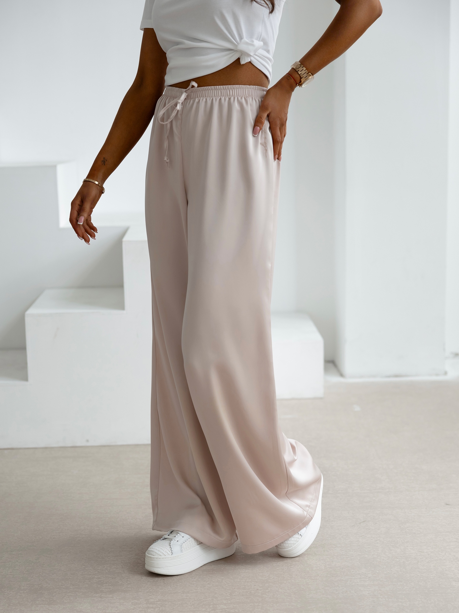 Spodnie z wyższym stanem dzwony NAVEEN OLAVOGA beżowe Spodnie z wyższym stanem dzwony NAVEEN OLAVOGA beżowe