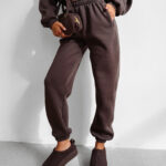 Komplet damski OLAVOGA SUMELY brązowy prezentowany na modelce przodem ze zbliżeniem na spodnie